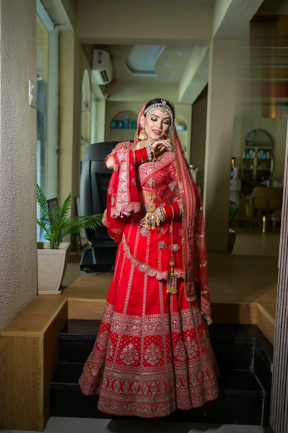Bride in a red lehenga, full bridal styling by Rare Salon