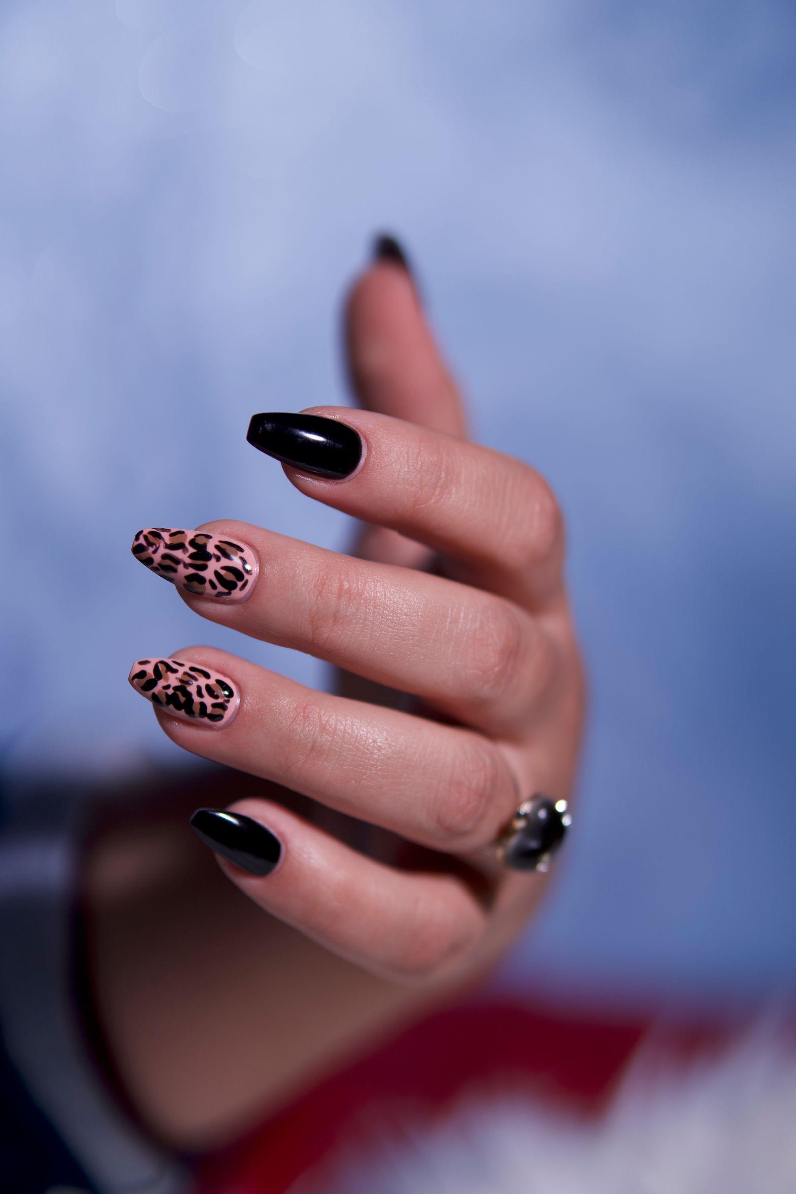 Black almond nails with gold leopard-print nail art