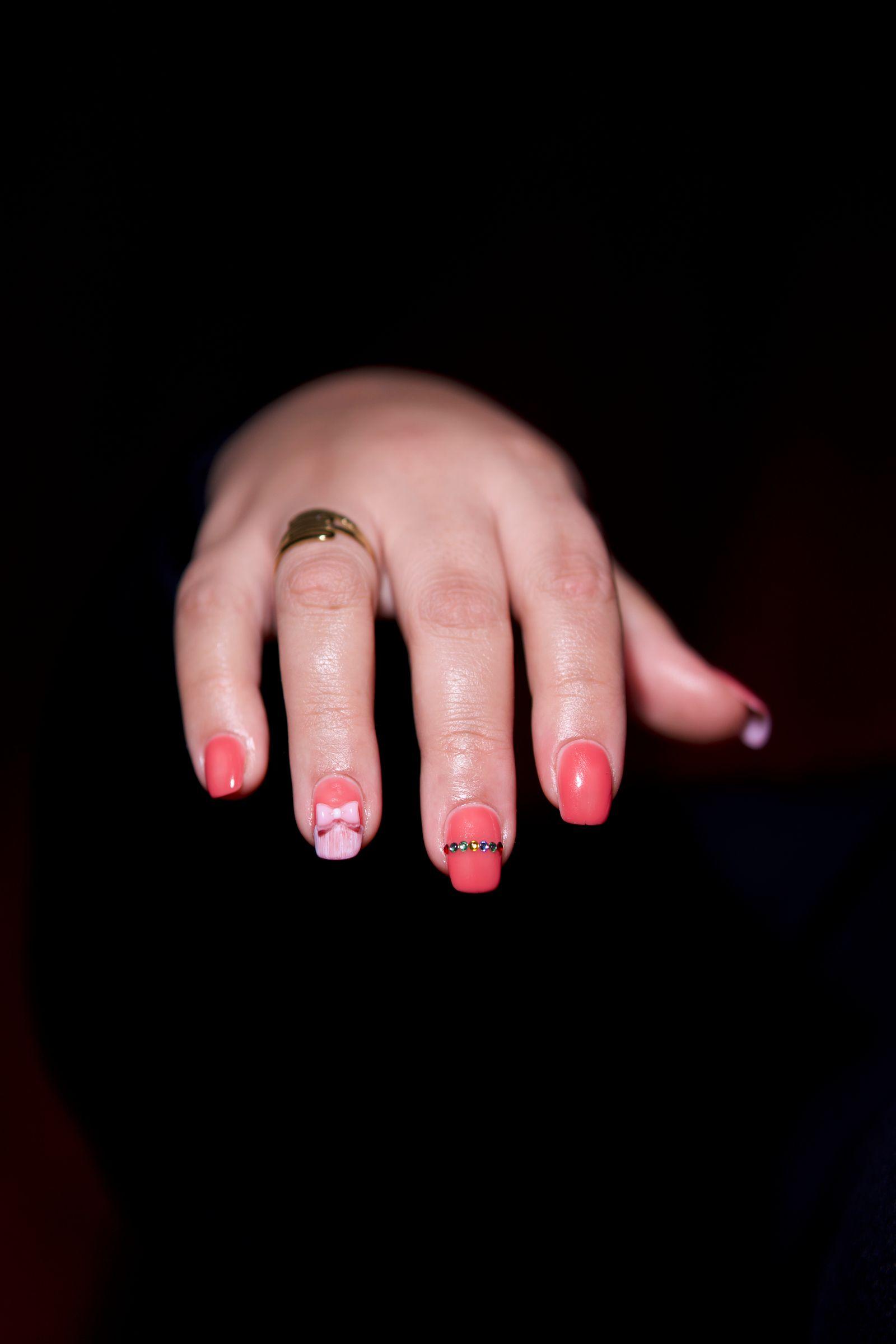Artistic red manicure detailed with a gold ring