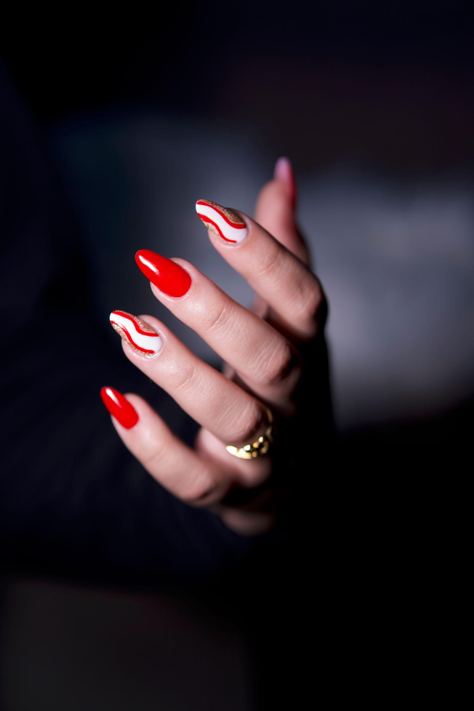 Elegant red and white nail art with a gold ring